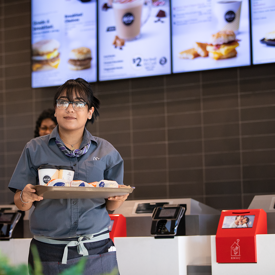 McDonald's employee holding a tray of food
